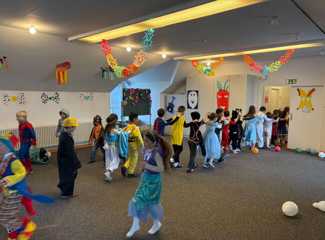 Kinder tanzen ausgelassen in Faschingskostümen