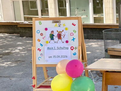 Eine aufgestellte Holztafel mit Plakat Mein 1. Schultag