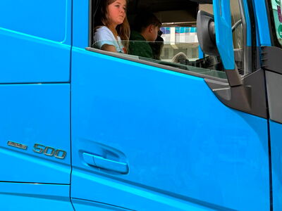 Eine Schülerin sieht aus dem offenen Fenster eines LKW-Führerhauses