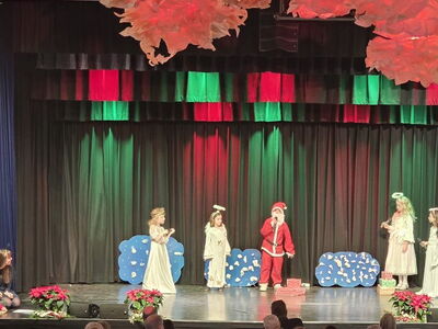 Kinder stehen als Engl und Nikolaus verkleidet auf der Bühne