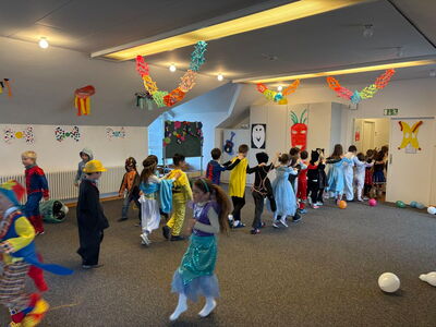 Kinder tanzen ausgelassen in Faschingskostümen