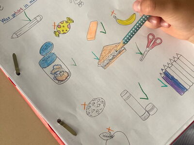 Eine Mappe mit Gegenständen, welche in die Schultasche gehören