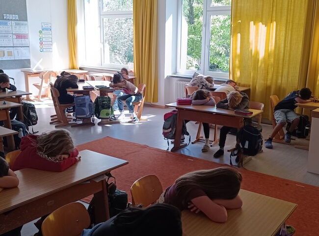 Schüler ruhen sich auf Schulbänken aus
