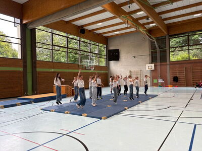 Schüler führen einen Tanz auf Sportmatten auf