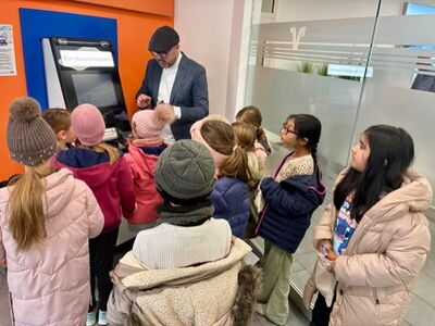 Die Klasse 1/2c vor einem Geldautomaten