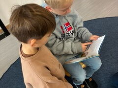 Zwei Schüler lesen aus einem Buch