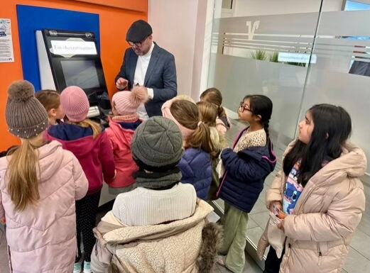 Die Klasse 1/2c vor einem Geldautomaten