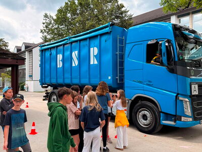 Eine Gruppe von Schülern steht vor einem großen LKW
