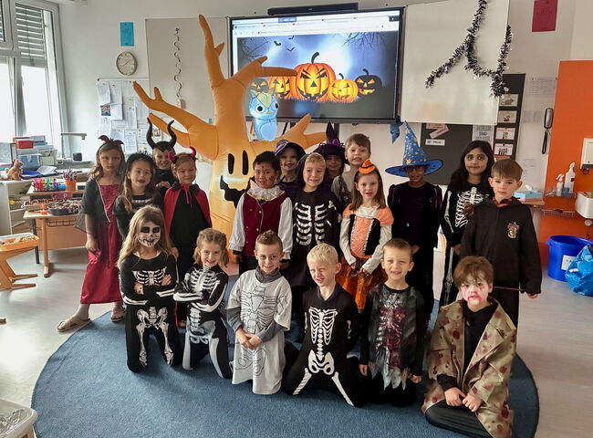 Gruppenfoto einer Schulklasse in gruseligen Halloweenkostümen