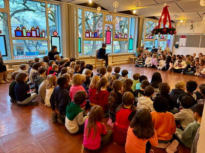 Schüler sitzen zusammen auf dem Boden