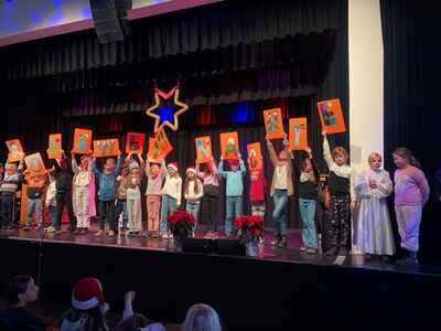Kinder halten Schilder mit Buchstaben hoch